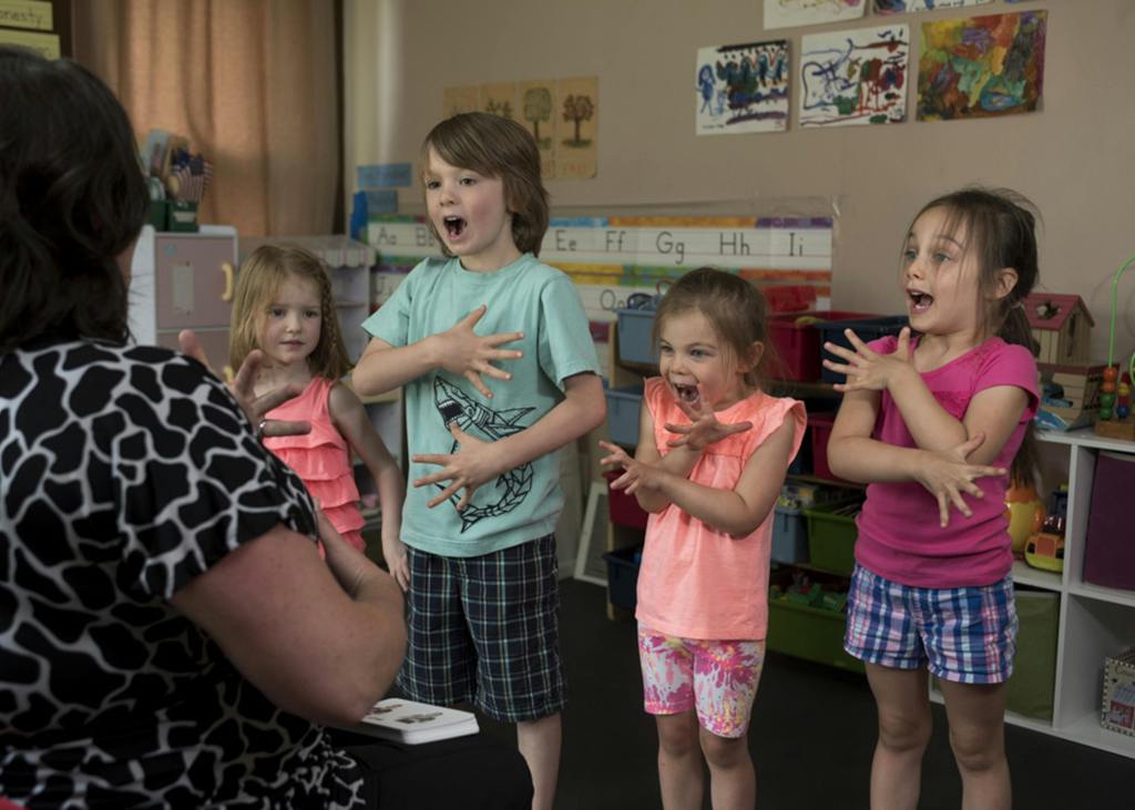 Children doing movement and finger play in circle time