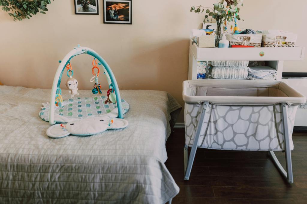 Nursery with a bassinet, changing table, and play mat