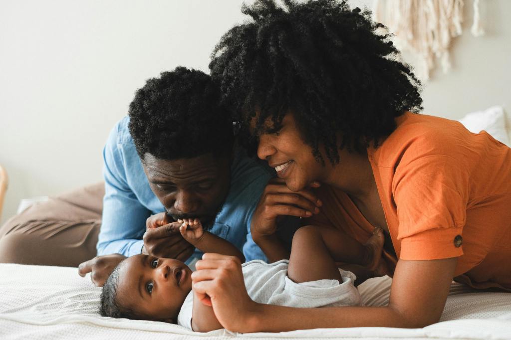 mother and father kissing their baby