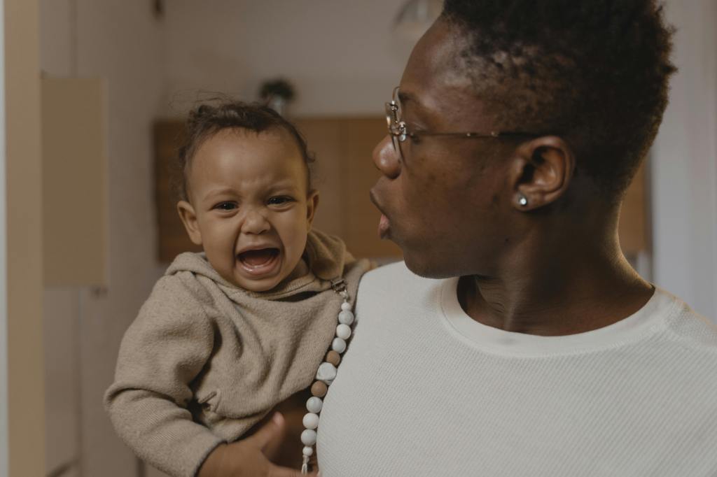 mom holding crying tired baby